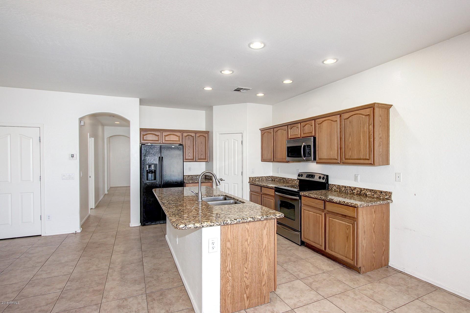 3036 East St John Road Phoenix, AZ 85032 - Photo 9 of 33 a large kitchen with stainless steel appliances granite countertop a stove and a sink