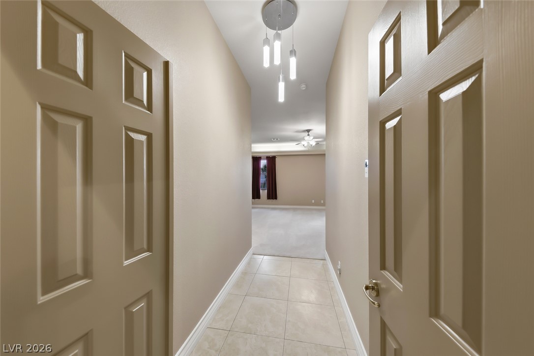 1104 Norellat Road Henderson, NV 89011 - Photo 24 of 52 Tiled flooring and warm neutral walls define this welcoming hallway leading to an open living area.
