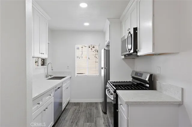 a kitchen with stainless steel appliances white cabinets and a stove top oven
