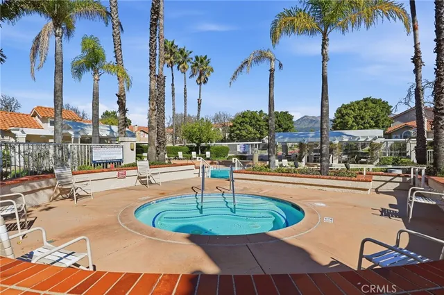 a view of a swimming pool with a table and chairs potted plants
