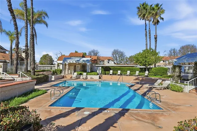 a view of a house with a swimming pool and sitting area