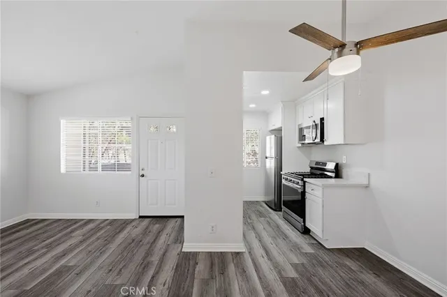 a kitchen with granite countertop a stove cabinets and wooden floor