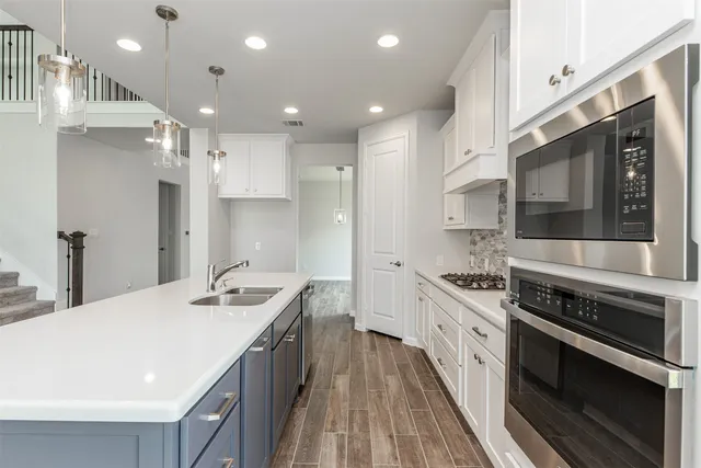 a kitchen with stainless steel appliances kitchen island granite countertop a sink stove and cabinets