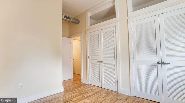 an empty room with wooden floor and windows