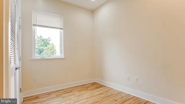 a view of kitchen with stainless steel appliances wooden floor and chair