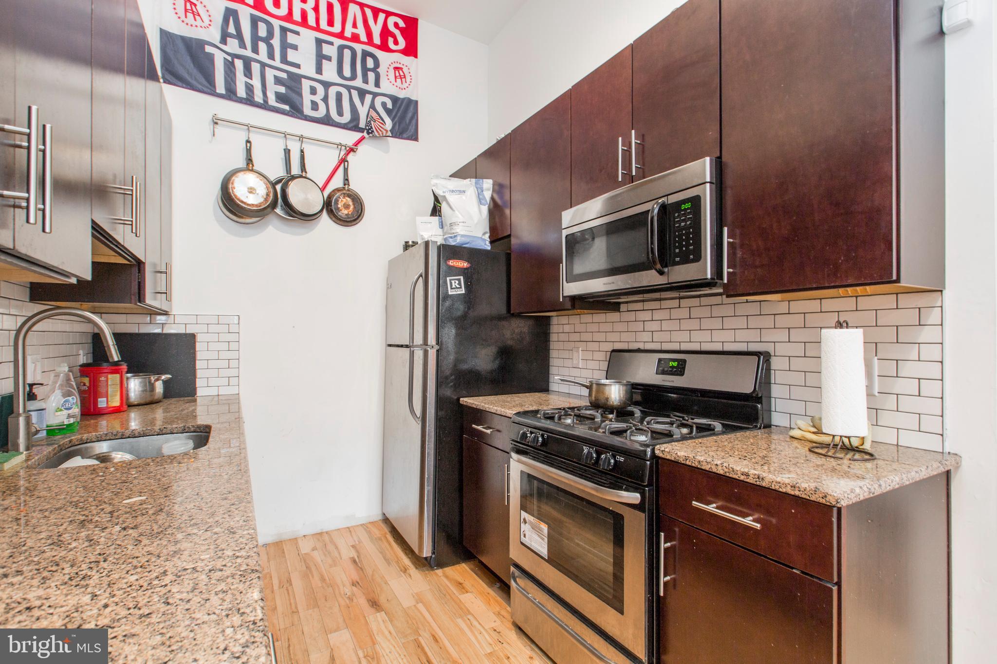 1234 North 30th Street Philadelphia, PA 19121 - Photo 5 of 59 a kitchen with stainless steel appliances granite countertop a stove and a microwave