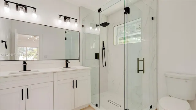 a bathroom with a shower sink vanity and mirror