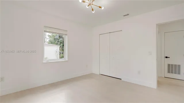 an empty room with windows and closet