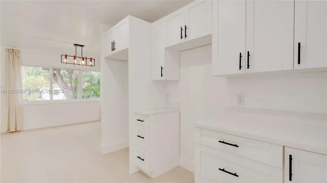 a view of kitchen with cabinets and window