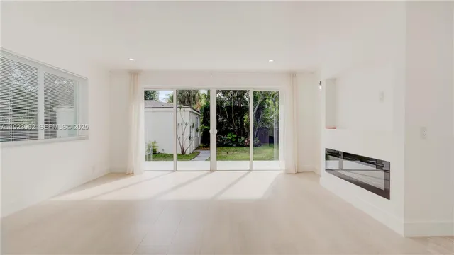 a view of a room with furniture large windows and flat screen tv