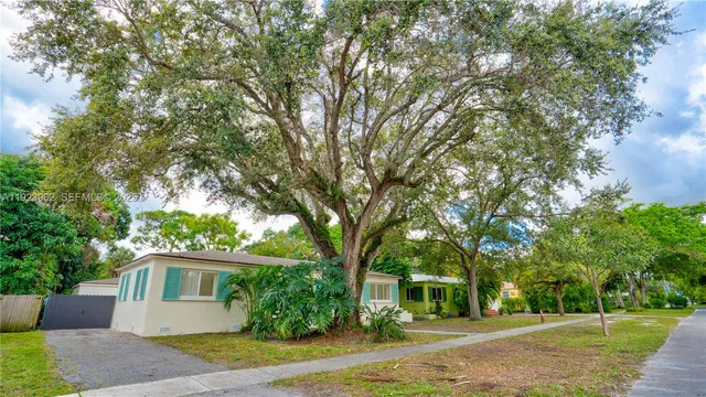 a front view of a house with a yard and trees