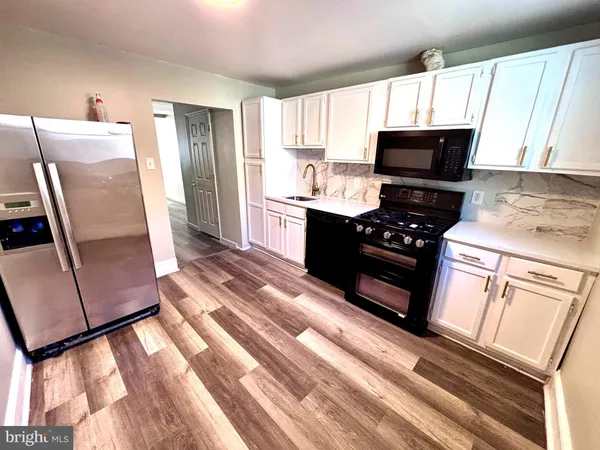 a kitchen with granite countertop a refrigerator stove and microwave