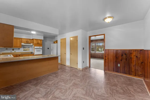 a kitchen with a table chairs and a wooden floor
