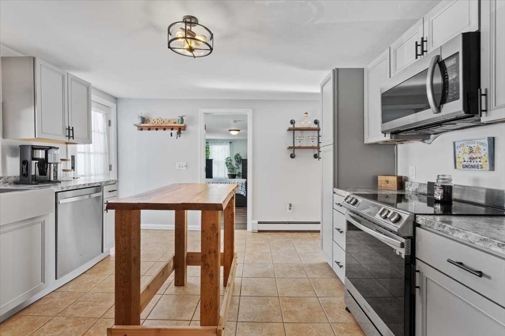 38 Watch Street Rochdale, MA 01542 - Photo 15 of 42 a kitchen with stainless steel appliances granite countertop a stove top oven a sink a microwave and a refrigerator