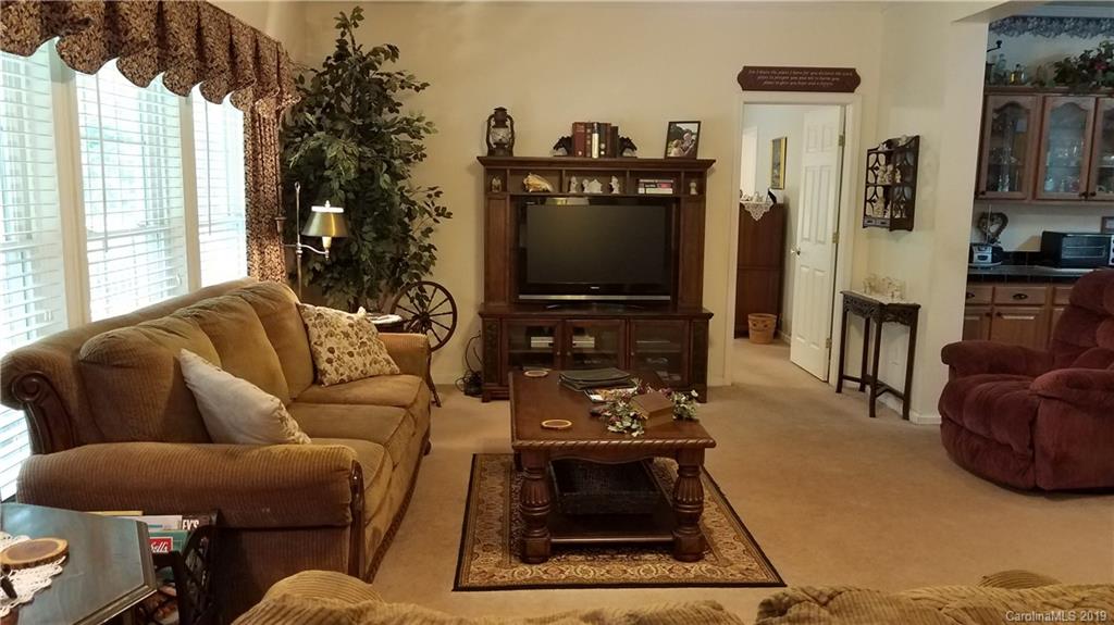 732 Lookout Tower Road Blacksburg, SC 29702 - Photo 9 of 31 a living room with furniture a flat screen tv and a floor to ceiling window