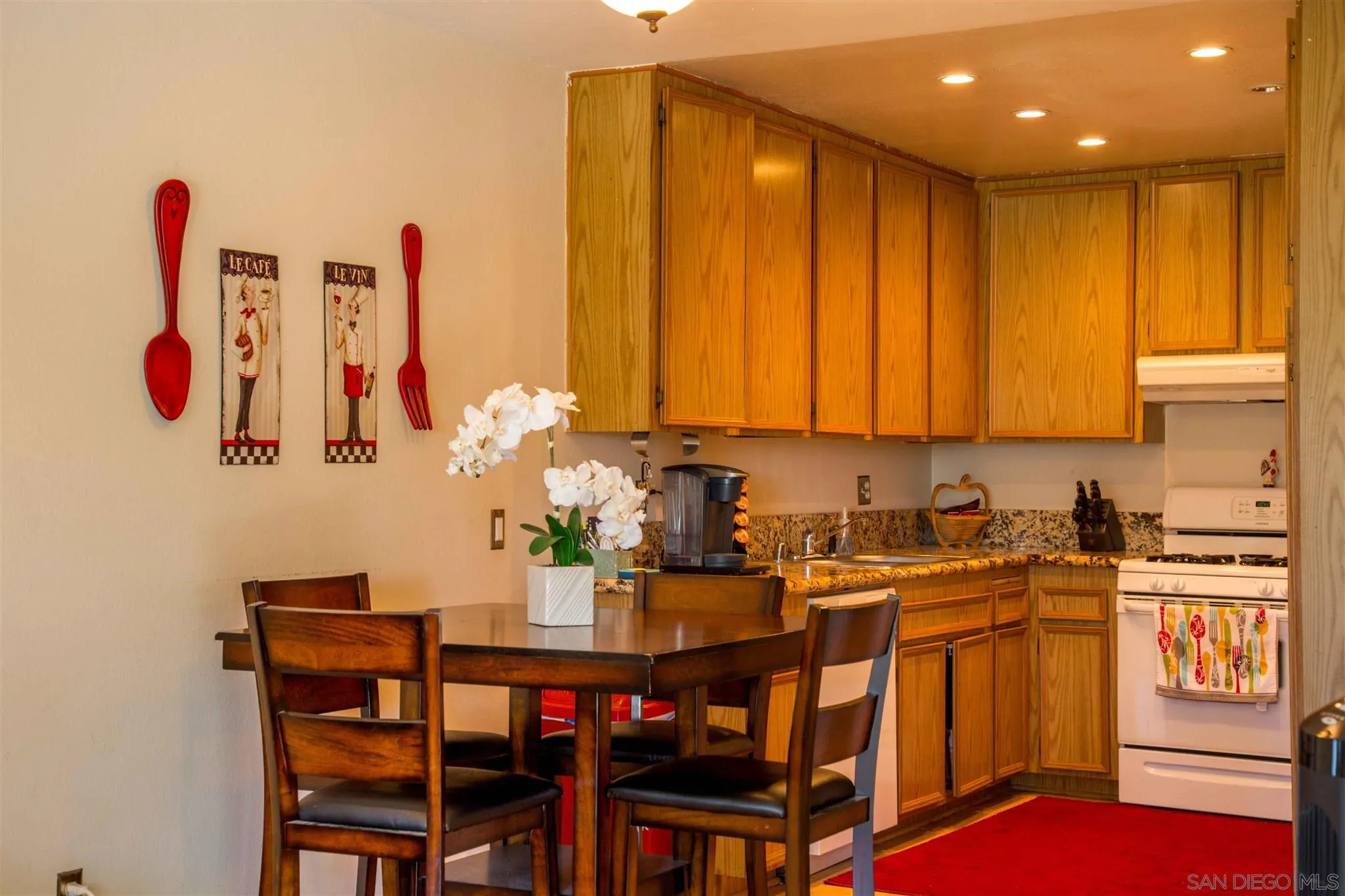 10384 Alphonse Street, Unit E6 Santee, CA 92071 - Photo 11 of 26 a kitchen with a table chairs sink and cabinets