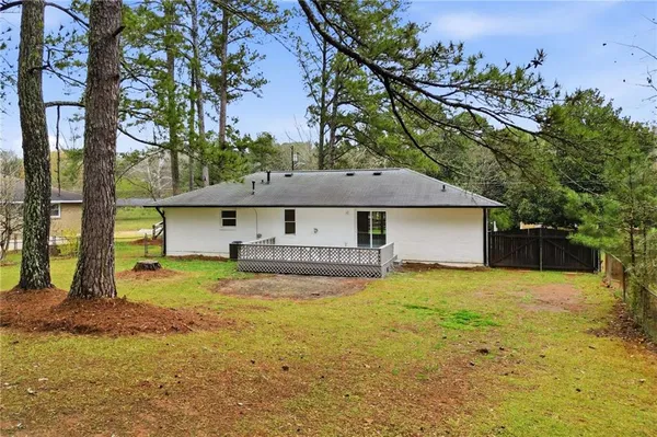 a view of a house with a big yard and large tree