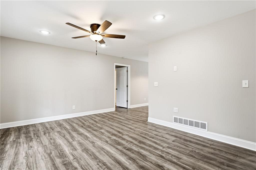 4319 Tradition Terrace Austell, GA 30106 - Photo 7 of 46 a view of an empty room with wooden floor and a ceiling fan