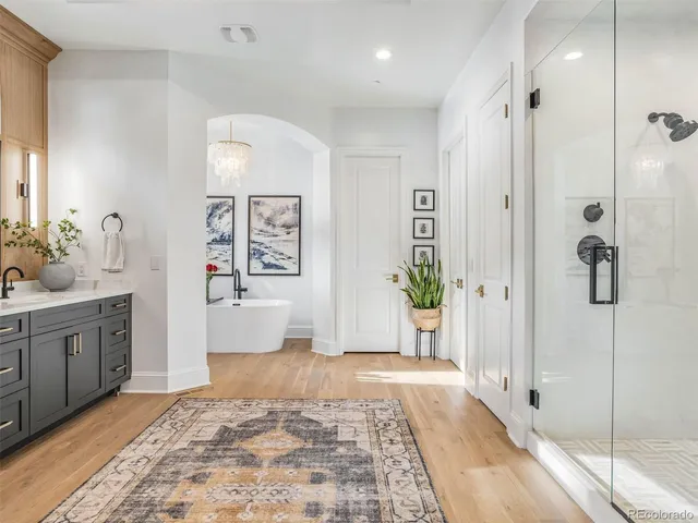 a spacious bathroom with a granite countertop sink a mirror a bathtub and shower