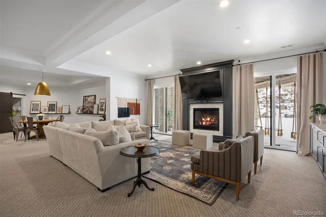 a living room with furniture fireplace and a large window