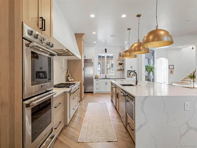 a large kitchen with stainless steel appliances granite countertop a stove a sink and a refrigerator