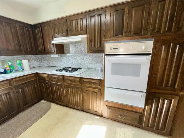 a kitchen with wooden cabinets and a stove top oven