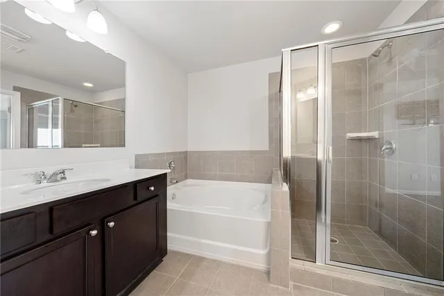 a bathroom with a bathtub shower sink vanity and toilet