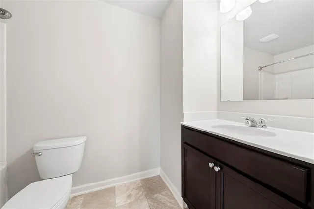 a bathroom with a granite countertop sink and a toilet