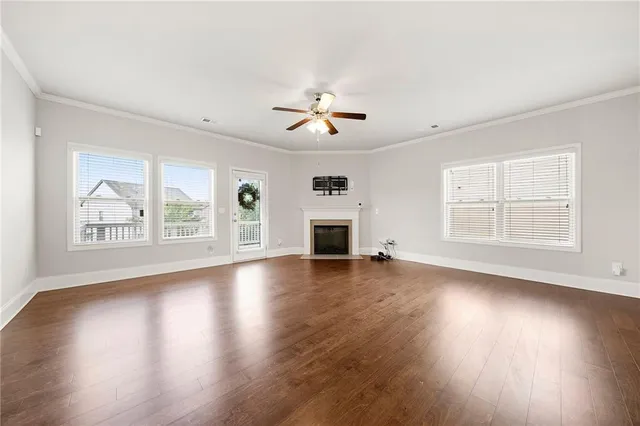 a view of an empty room with window and wooden floor