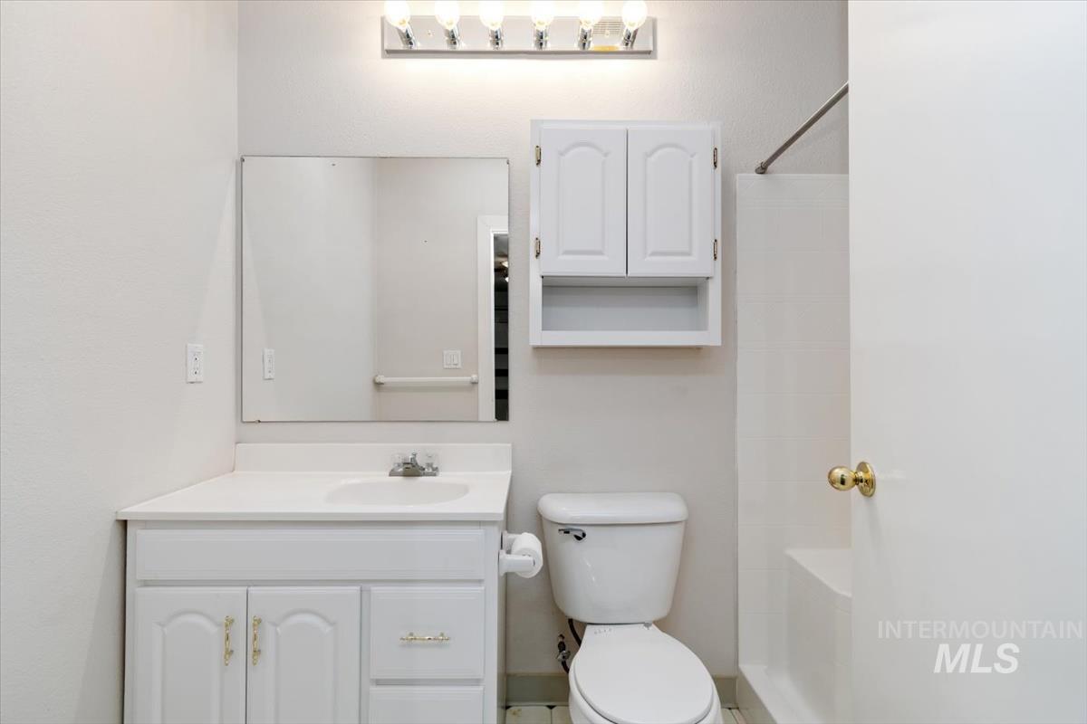 10462 West Lanktree Gulch Road Star, ID 83669 - Photo 35 of 48 Full bathroom featuring a white vanity with integrated sink, chrome faucet, wall-mounted mirror, and overhead vanity light