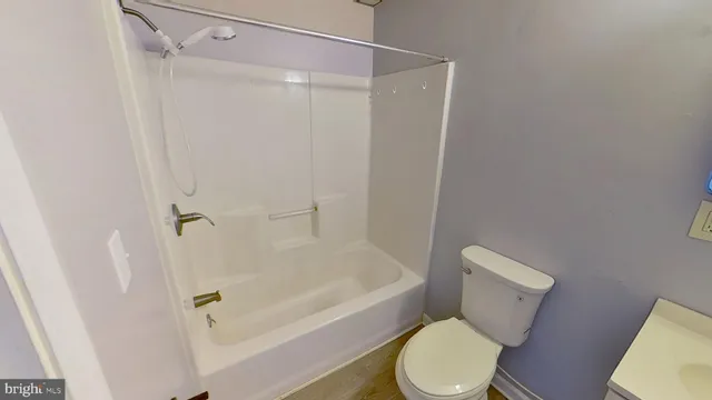 a white toilet sitting next to a bath tub