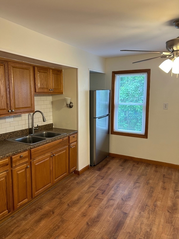 a kitchen with stainless steel appliances granite countertop a sink cabinets and wooden floor
