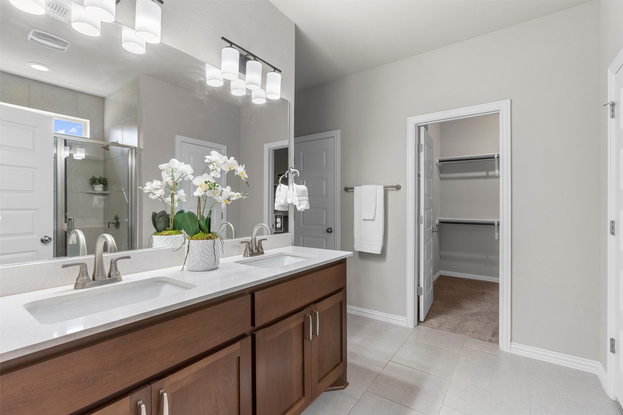 4216 Mercer Road Georgetown, TX 78628 - Photo 15 of 40 Bathroom with double vanity, a shower stall, a walk in closet, and light tile patterned floors