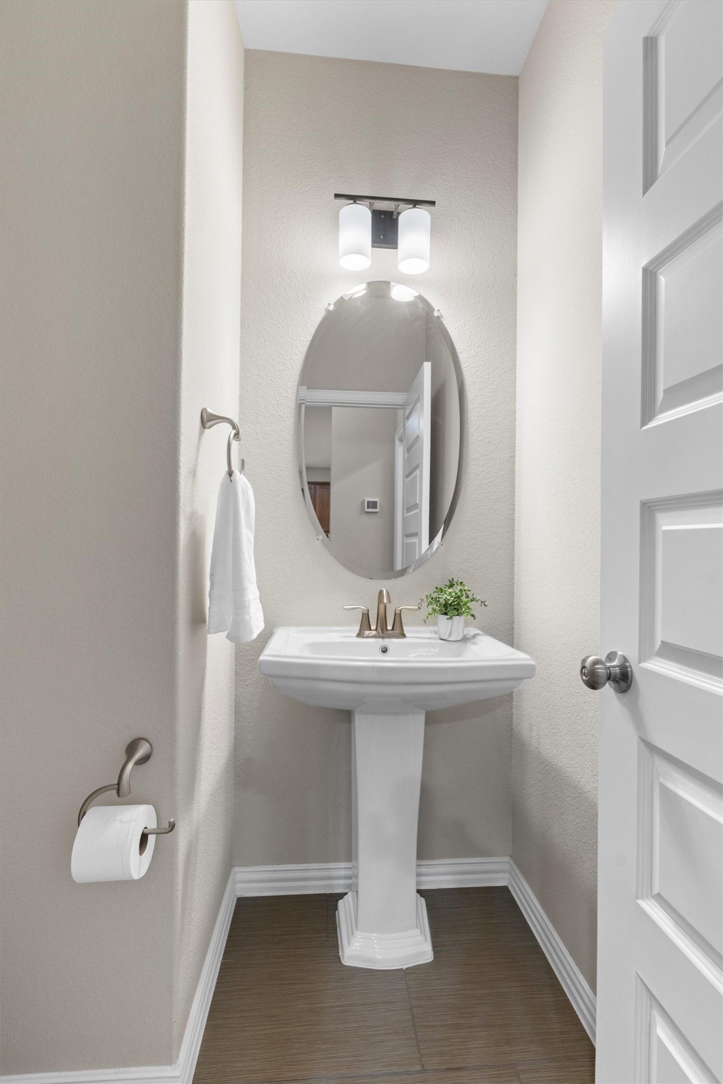 4216 Mercer Road Georgetown, TX 78628 - Photo 19 of 40 Half bathroom located on the main level features a classic pedestal sink, neutral finishes, and an elegant framed mirror