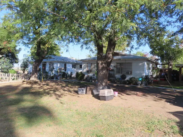 a front view of a house with a yard covered with trees