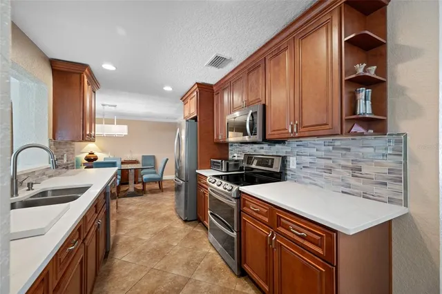 a kitchen with stainless steel appliances granite countertop a sink stove and refrigerator