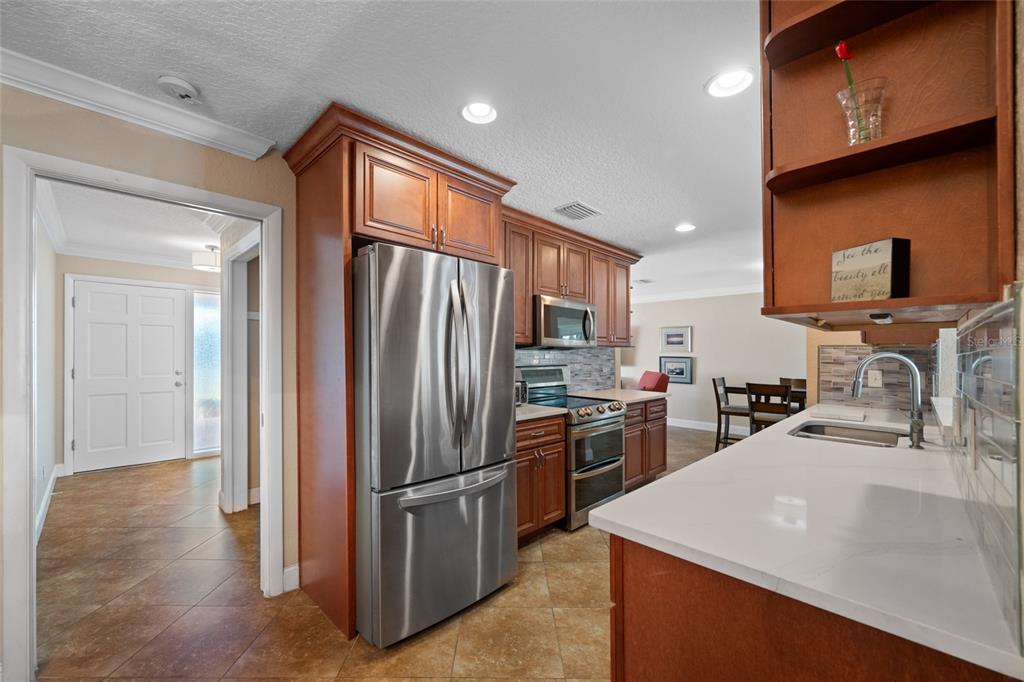 12957 90th Terrace Seminole, FL 33776 - Photo 13 of 31 a kitchen with stainless steel appliances granite countertop a refrigerator a stove top oven a sink and dishwasher