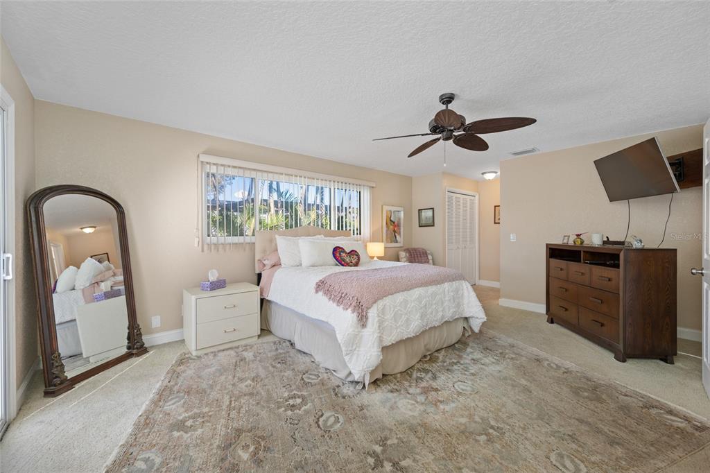 12957 90th Terrace Seminole, FL 33776 - Photo 22 of 31 a spacious bedroom with a bed and a chandelier