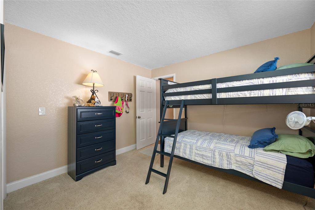 12957 90th Terrace Seminole, FL 33776 - Photo 26 of 31 a bedroom with a bed and lamp