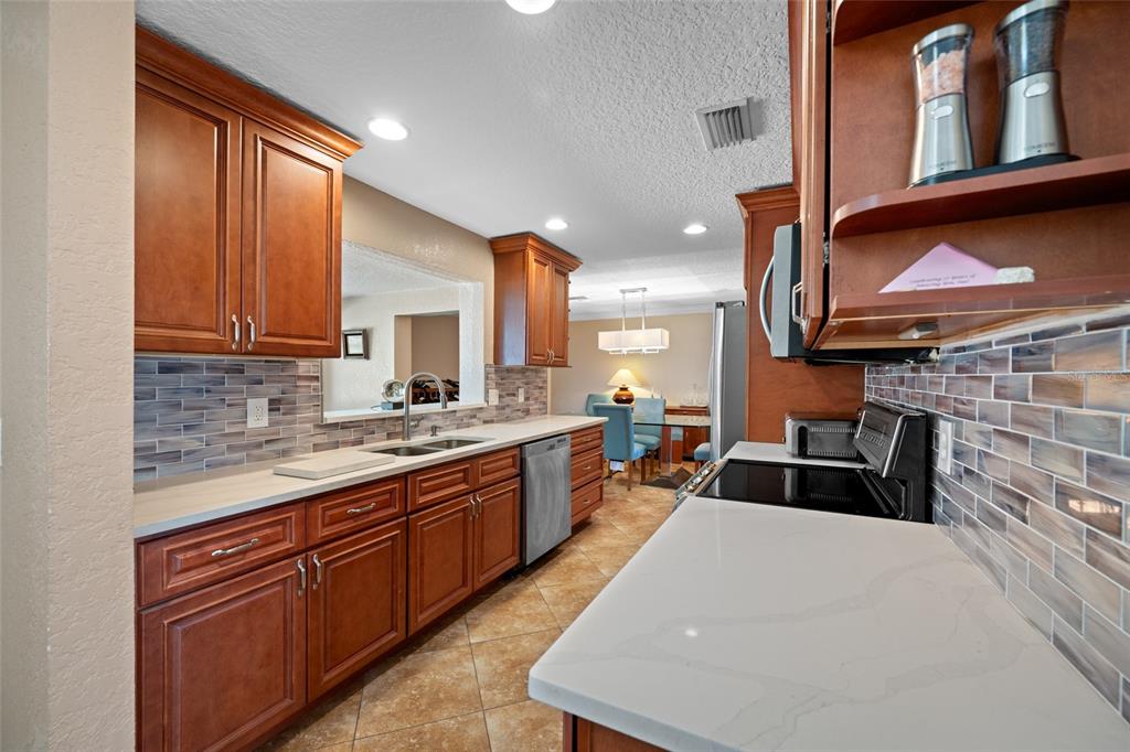 12957 90th Terrace Seminole, FL 33776 - Photo 10 of 31 a kitchen with granite countertop a sink stove and cabinets