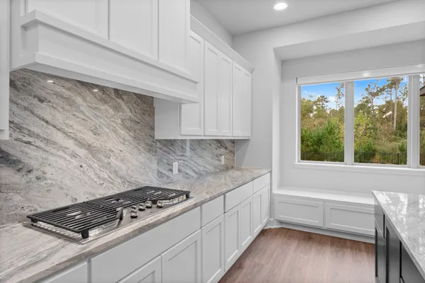 a kitchen with a stove and wooden floor