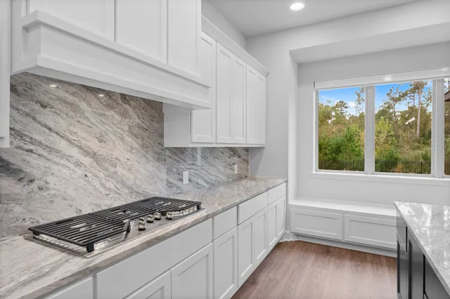 a kitchen with a stove and wooden floor