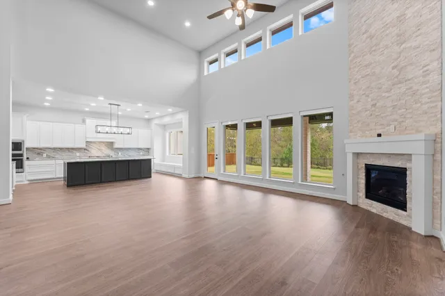 a view of an empty room with wooden floor and a fireplace