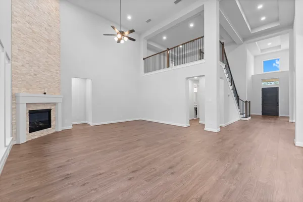 a view of an empty room with wooden floor and a fireplace