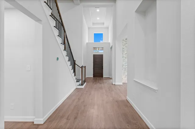 a view of a hallway with wooden floor and staircase
