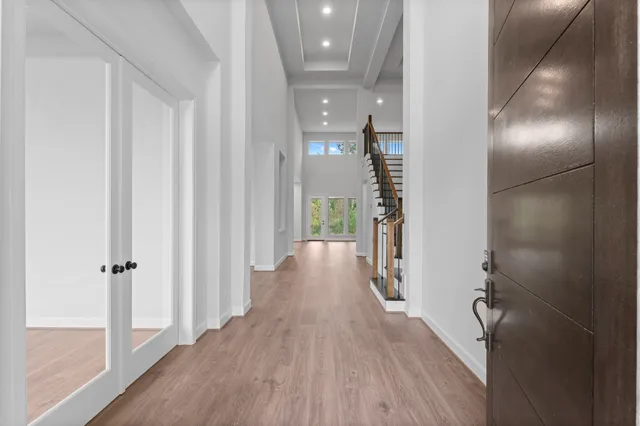 a view of a hallway with wooden floor and closet area