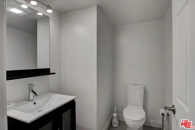 a bathroom with a toilet a sink and mirror
