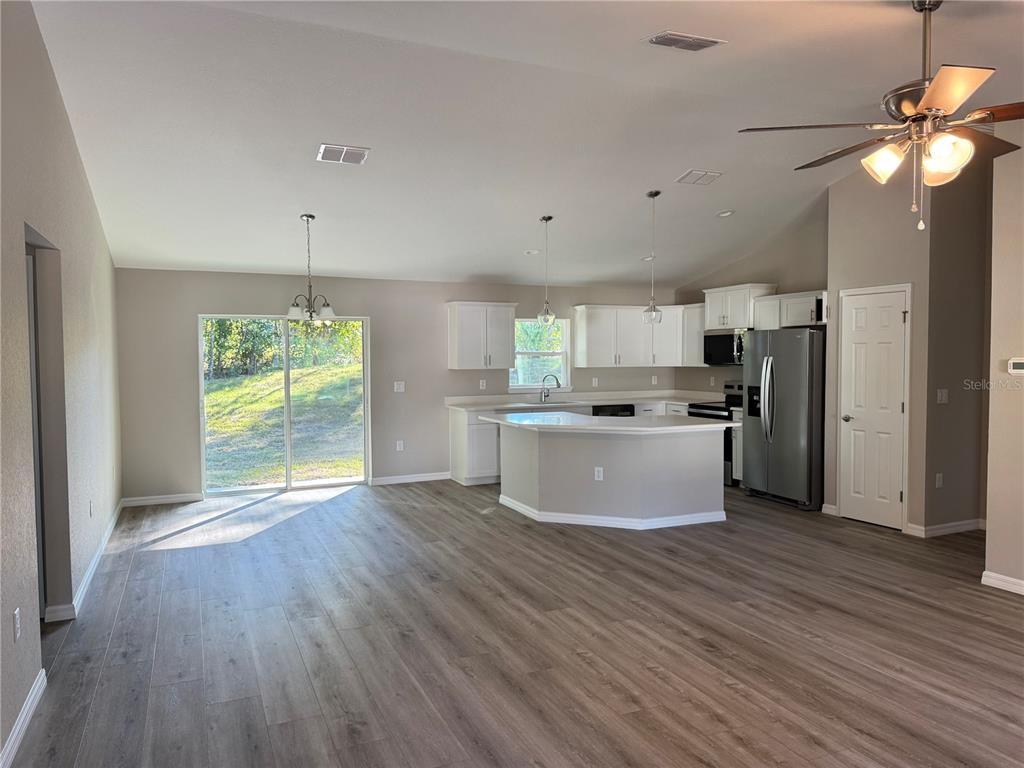 19330 Southwest 91st Loop Dunnellon, FL 34432 - Photo 6 of 46 a large kitchen with kitchen island a stove a refrigerator a sink and a wooden floor