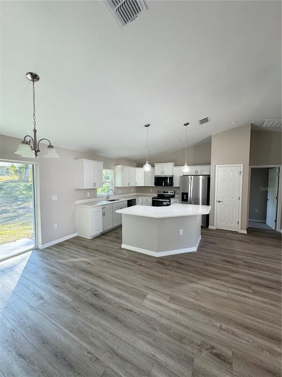 19330 Southwest 91st Loop Dunnellon, FL 34432 - Photo 7 of 46 a view of a kitchen with kitchen island a sink wooden floor and a refrigerator