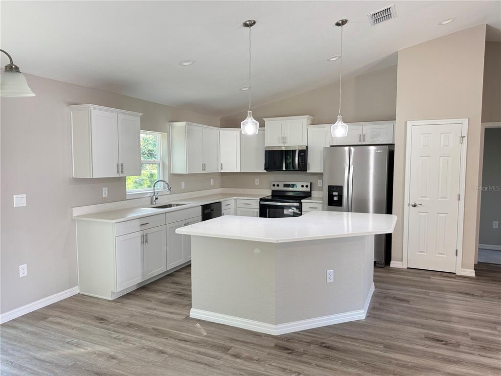 19330 Southwest 91st Loop Dunnellon, FL 34432 - Photo 10 of 46 a kitchen with stainless steel appliances a refrigerator a stove sink and white cabinets